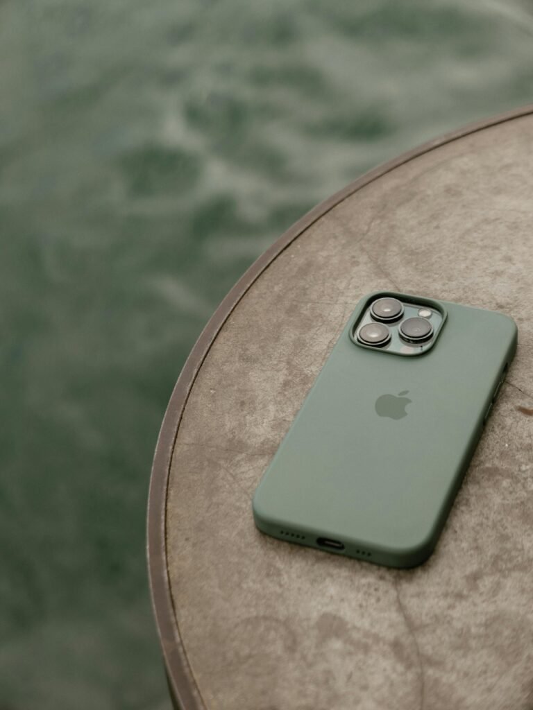 Green smartphone with triple camera on a round table, capturing modern minimalist design.